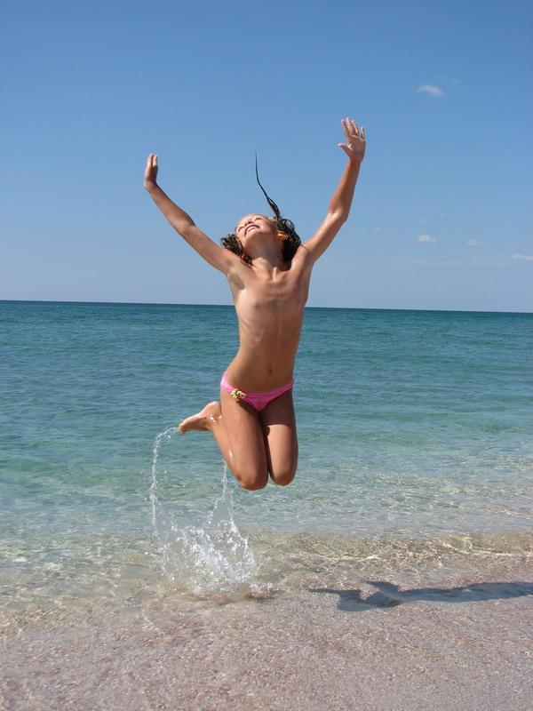 Ksenya prigaet vverh na dalnem plyazhe Belyausa